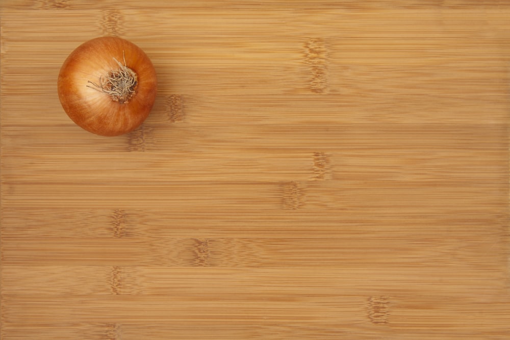 an onion sitting on top of a wooden cutting board