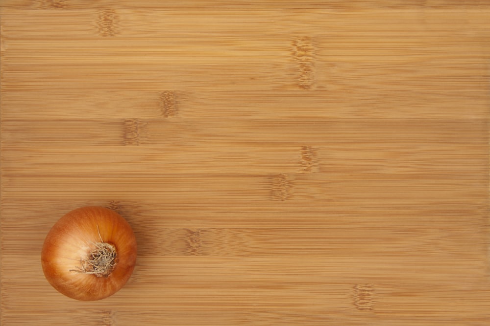 an onion sitting on top of a wooden cutting board