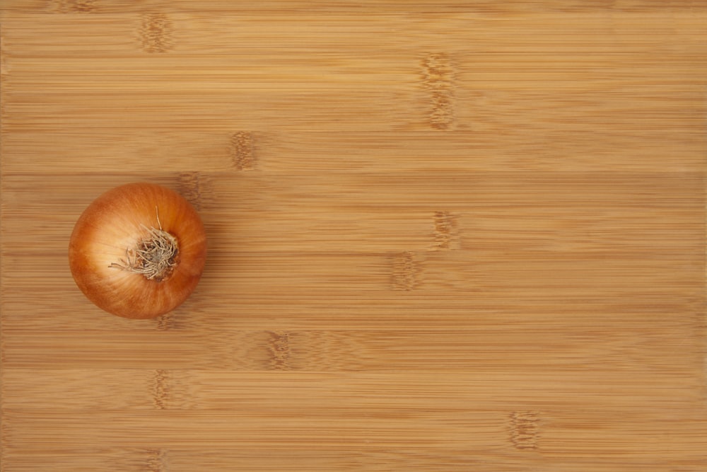 an onion sitting on top of a wooden cutting board
