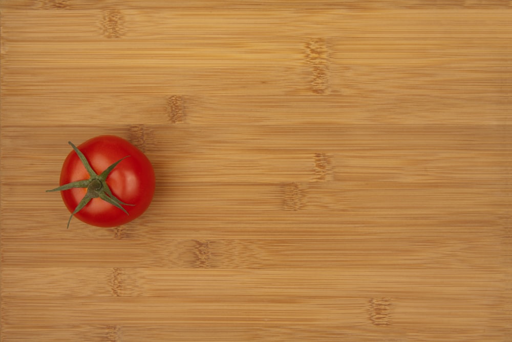 a tomato sitting on top of a wooden cutting board