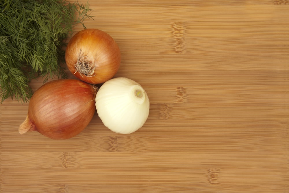 a couple of onions sitting on top of a wooden table