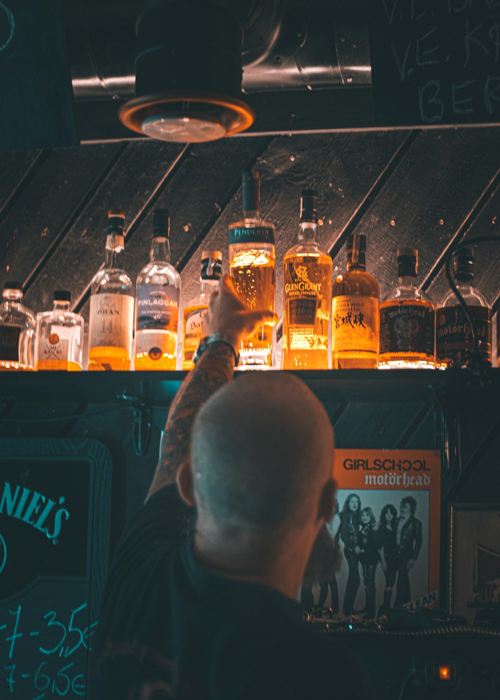 a man standing in front of a bar filled with bottles