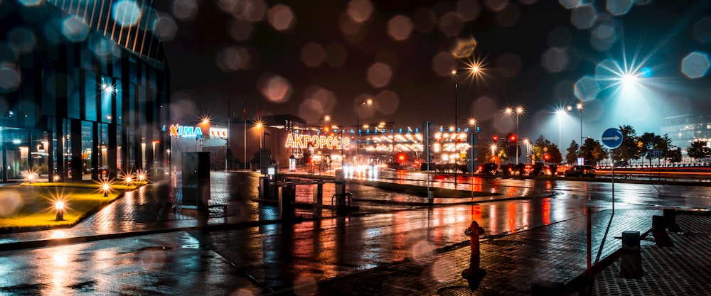 Una calle de la ciudad por la noche con luces y lluvia