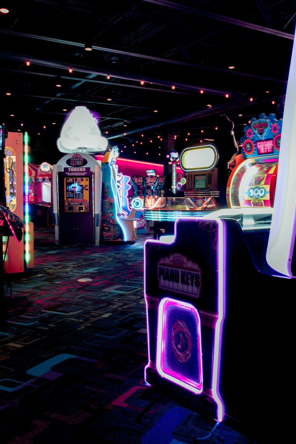 Une salle remplie de machines d’arcade et de néons