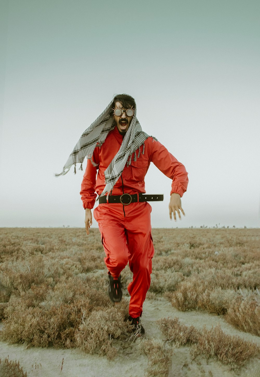 a man in a red jumpsuit in a field