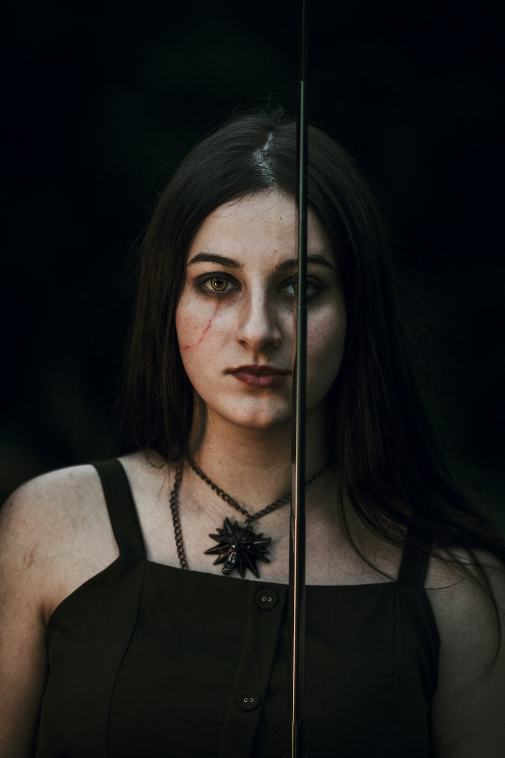 a woman with makeup on holding an umbrella