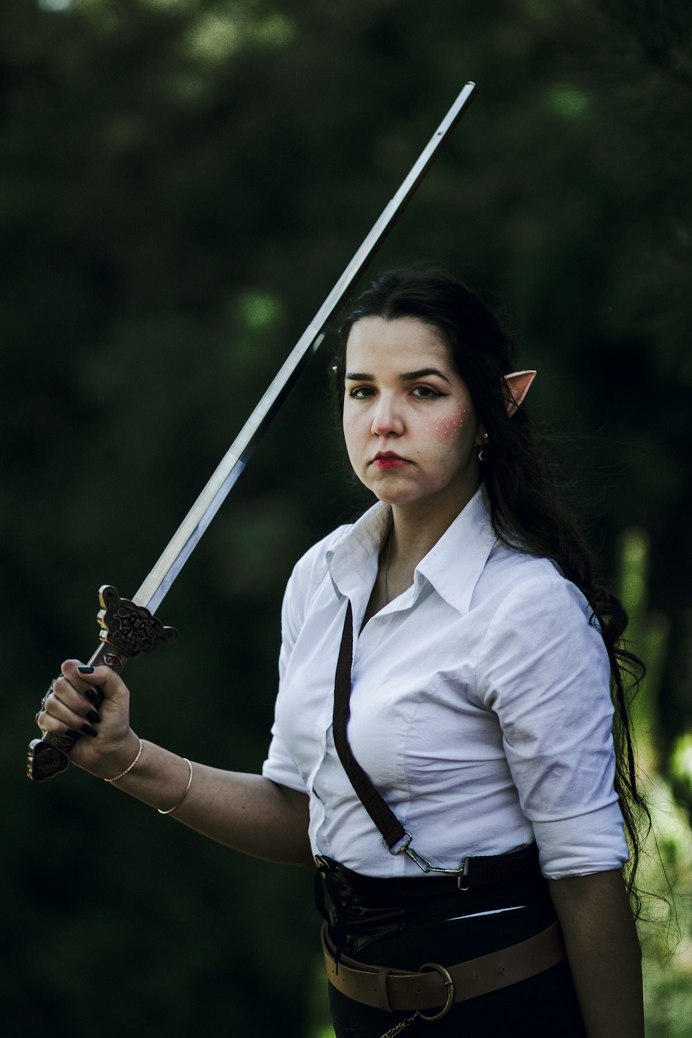 a woman in a white shirt holding a sword