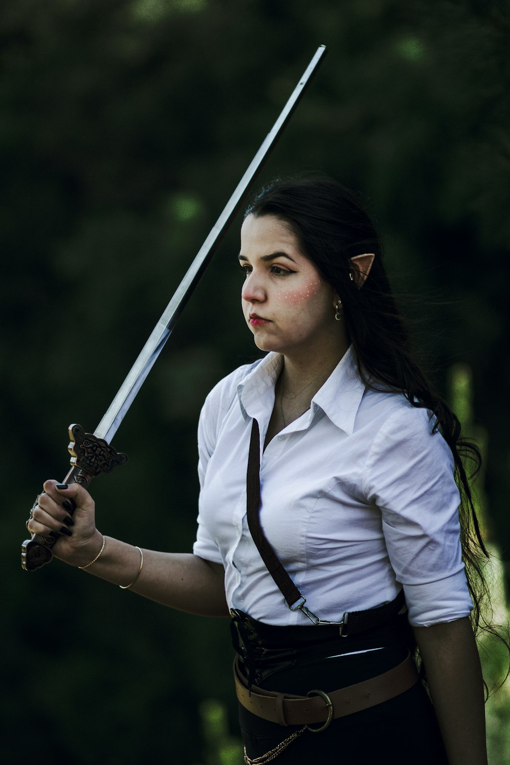 a woman in a white shirt holding a sword