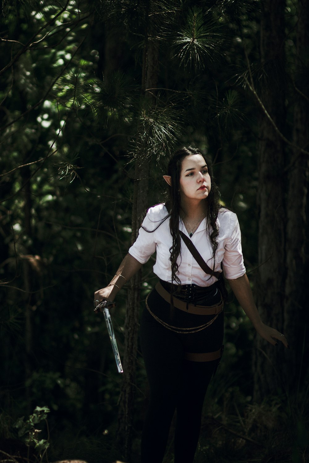 uma mulher com uma espada em uma floresta