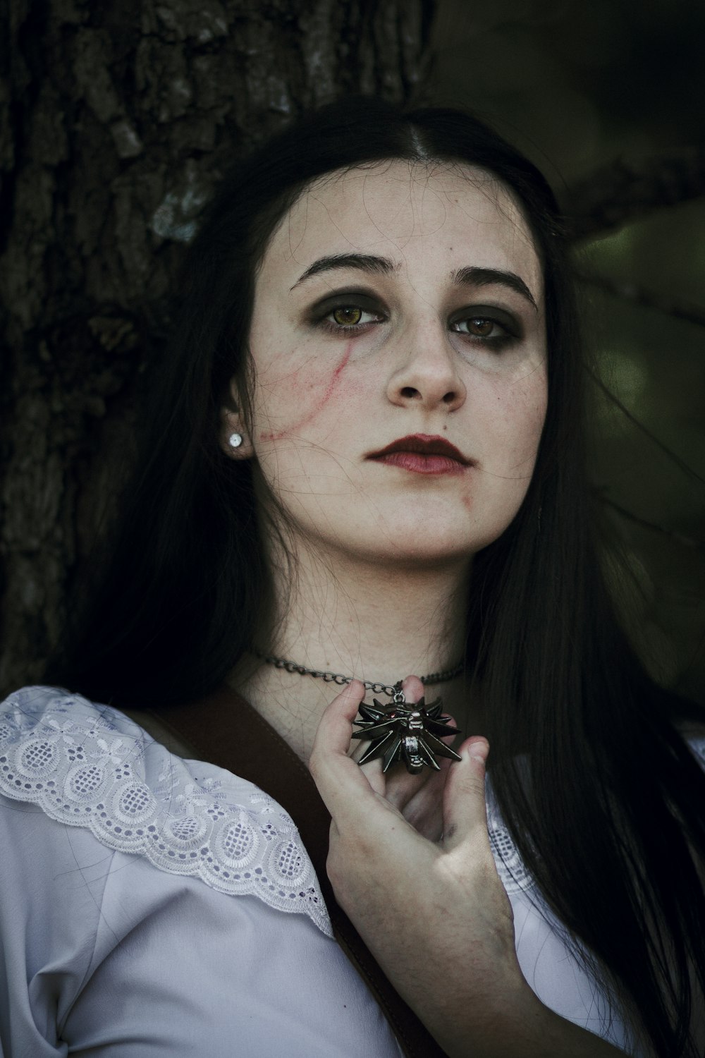 a woman with long black hair wearing a necklace