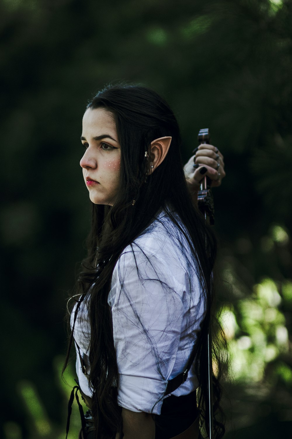 a woman with long black hair holding a stick