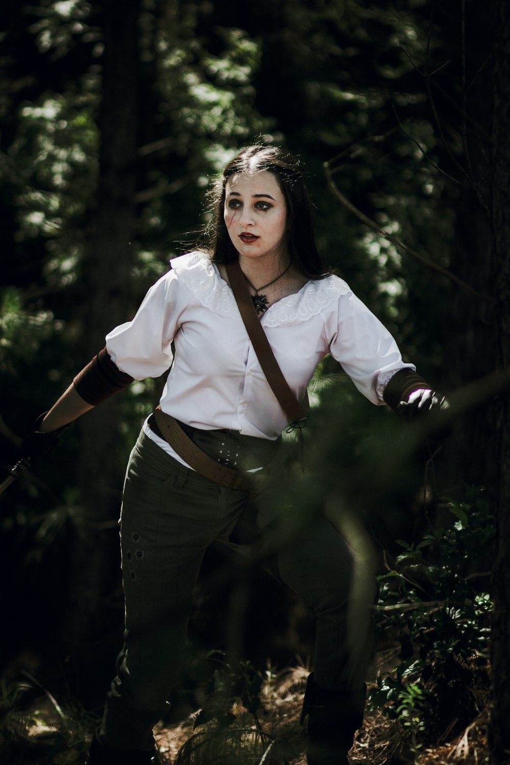 a woman in a white shirt and tie in the woods