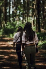 a couple of people that are walking in the woods