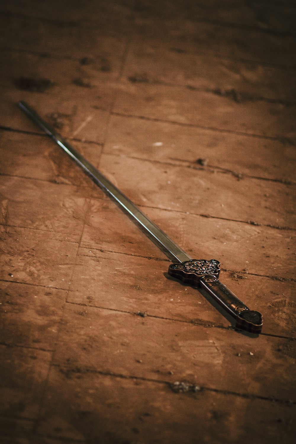 a sword laying on the ground on a wooden floor