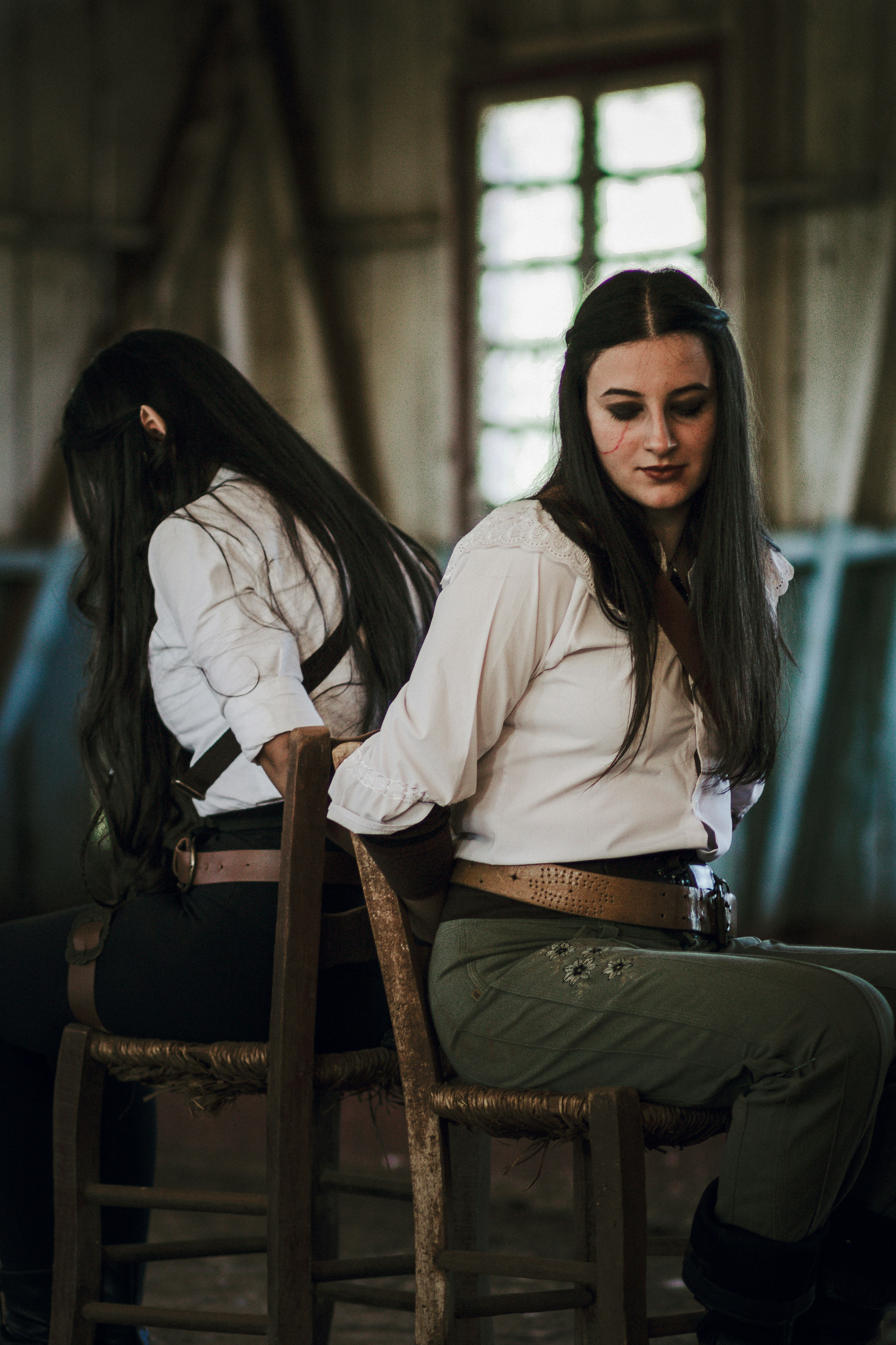 a woman sitting on top of a wooden chair