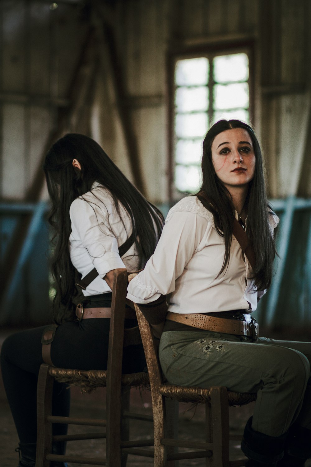 a woman sitting on top of a wooden chair