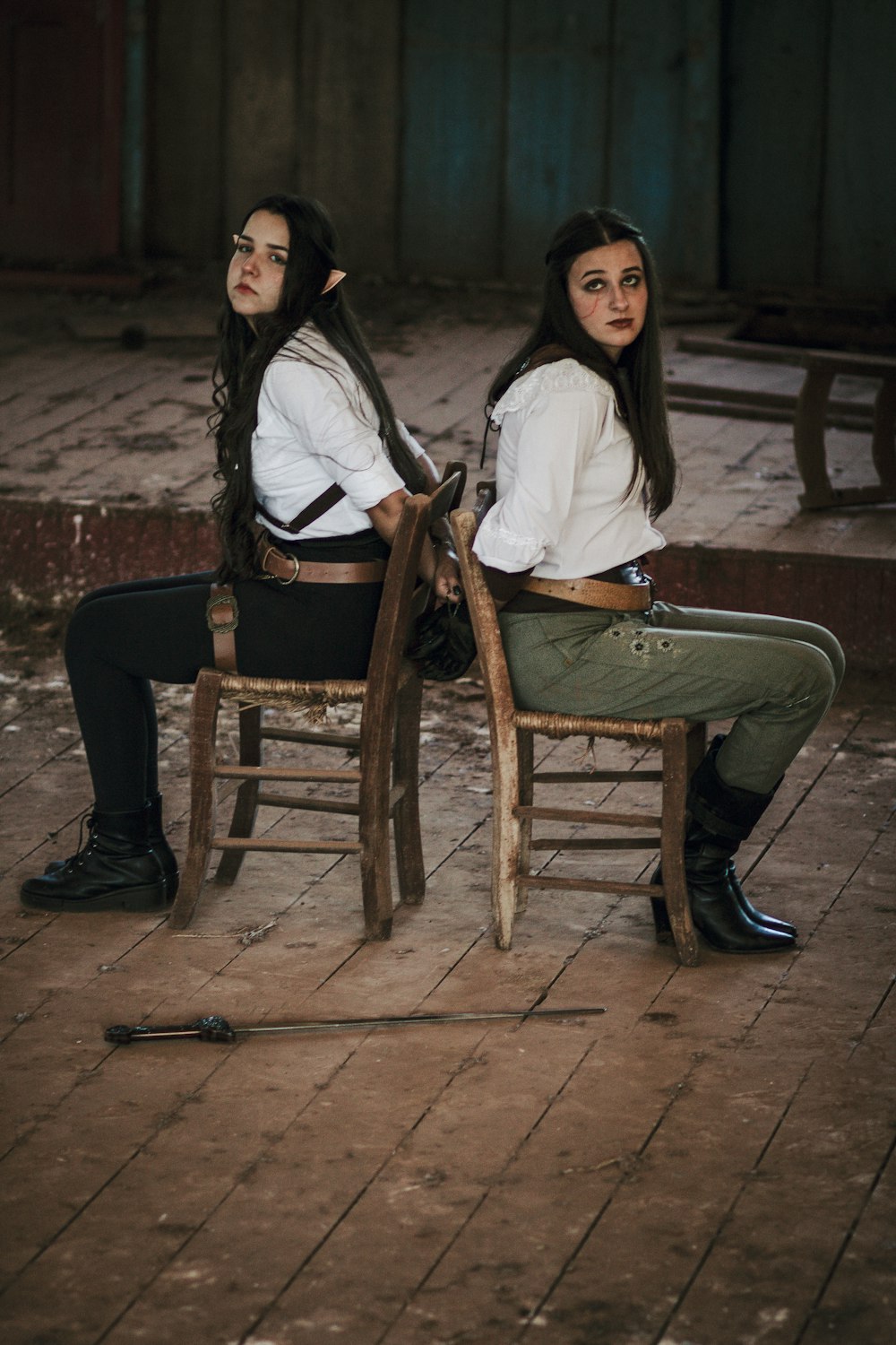 a couple of women sitting on top of wooden chairs