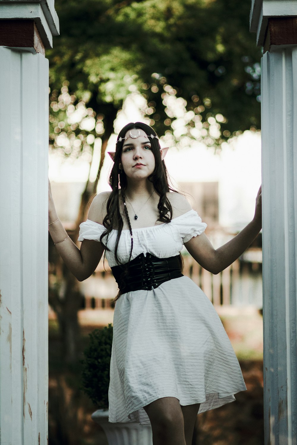 a woman in a white dress is standing in a doorway