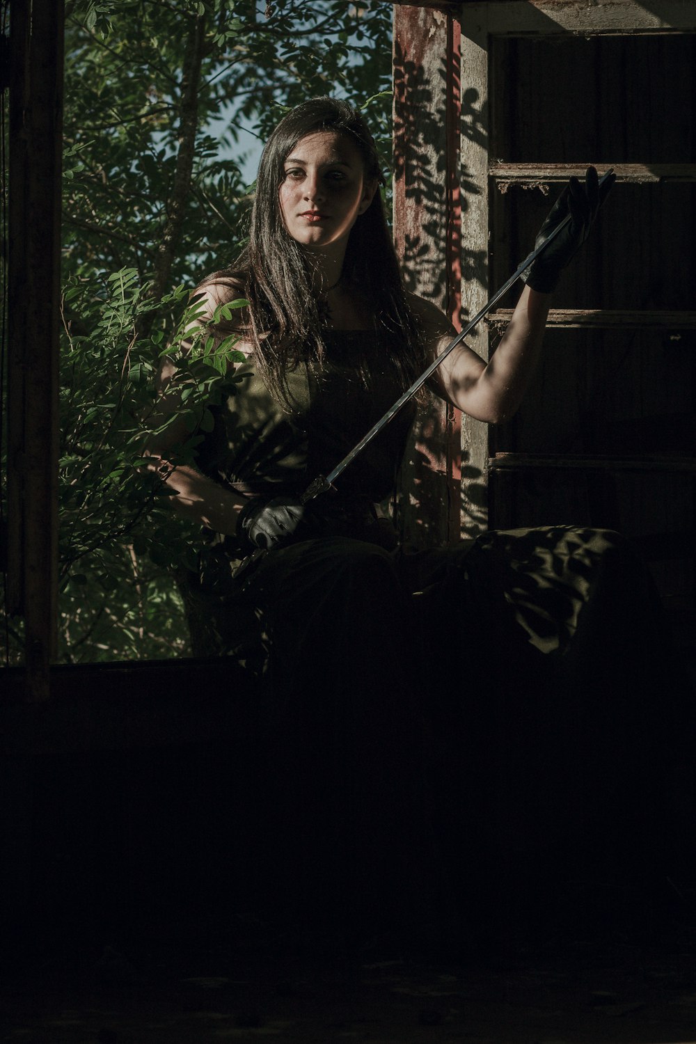 a woman in a black dress holding a sword