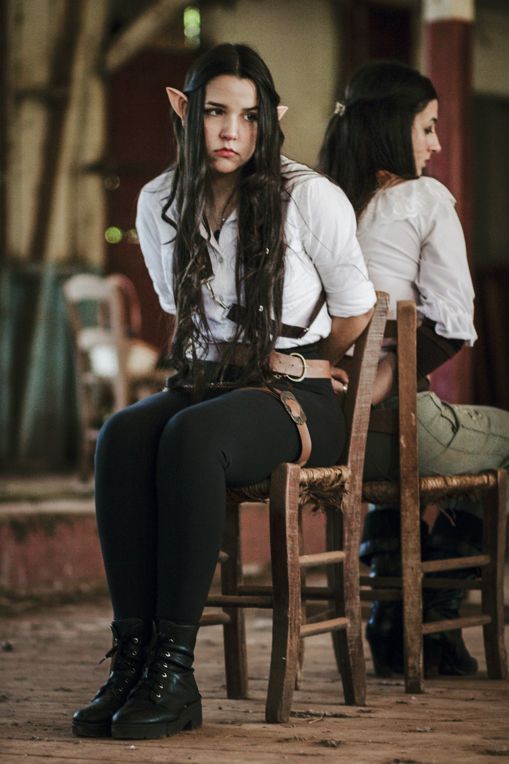 a woman sitting on top of a wooden chair