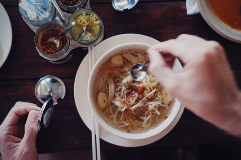 A bowl of sauerkraut soup with strands of cabbage and crisp bacon pieces in a rich broth