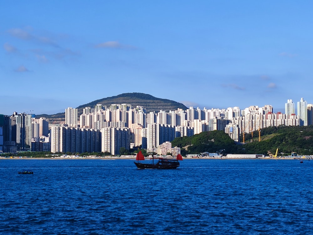 a boat in a body of water with a city in the background