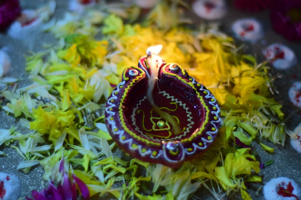 a lit candle sitting on top of a pile of flowers