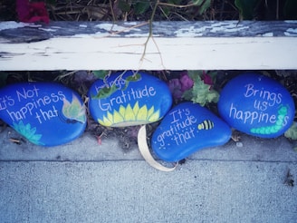 three painted rocks with words written on them
