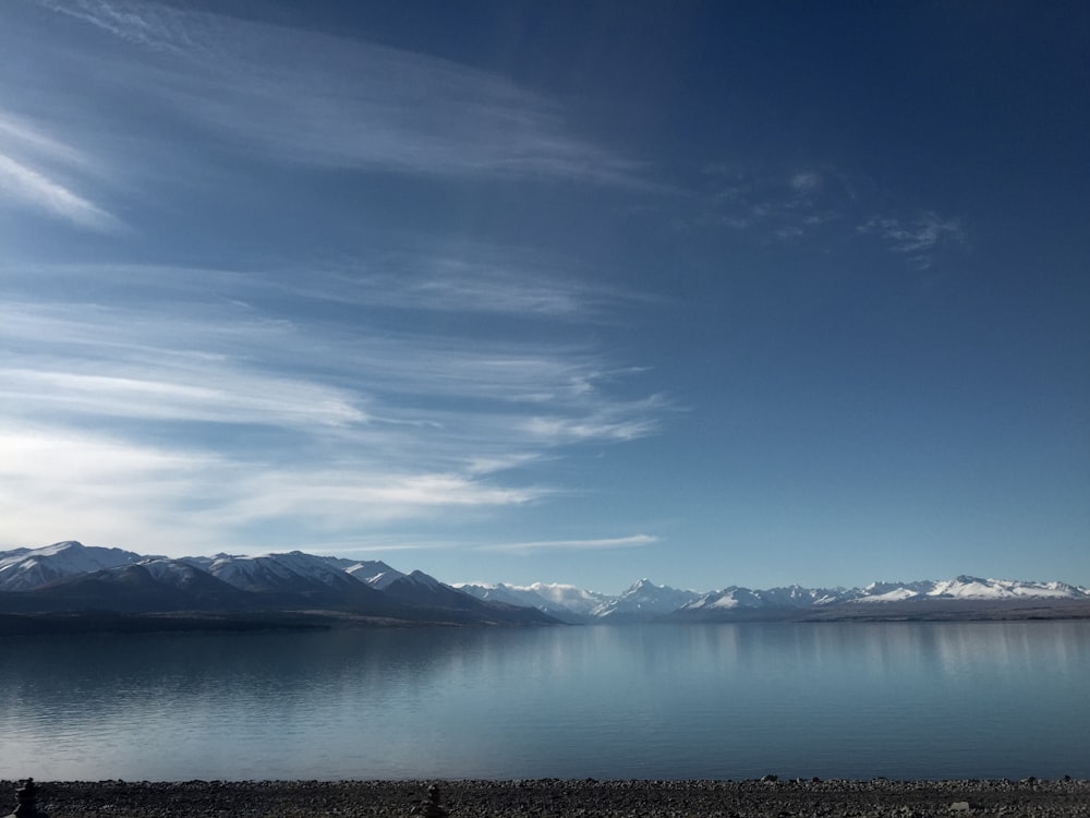 um lago com montanhas no fundo sob um céu azul