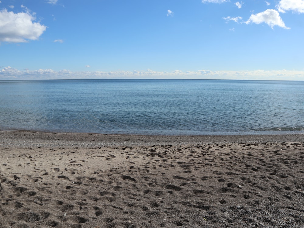 a sandy beach with a body of water in the background