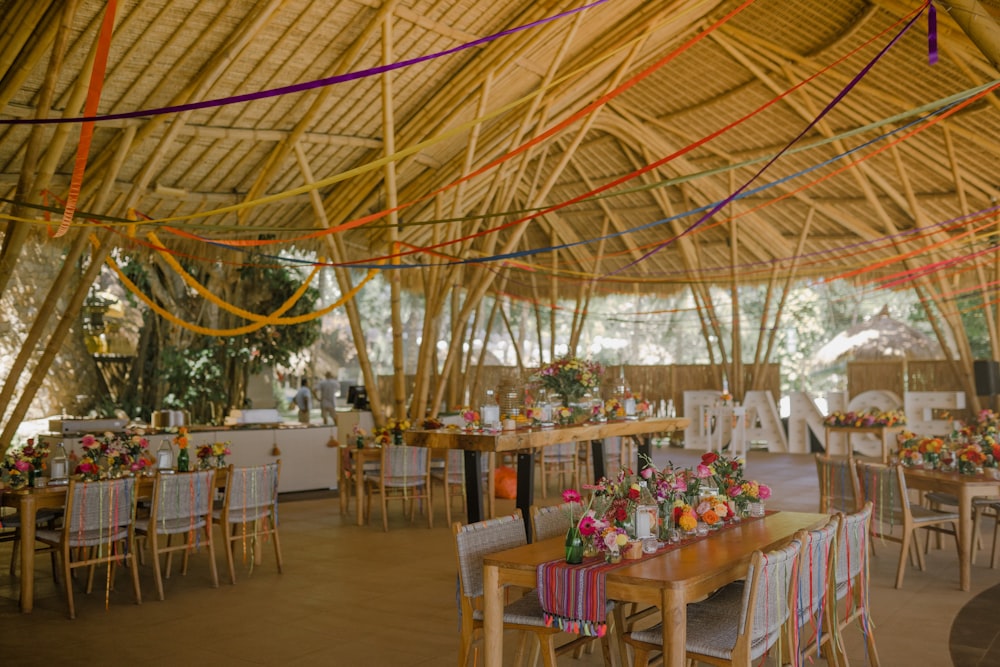 a dining area with tables, chairs, and a thatched roof