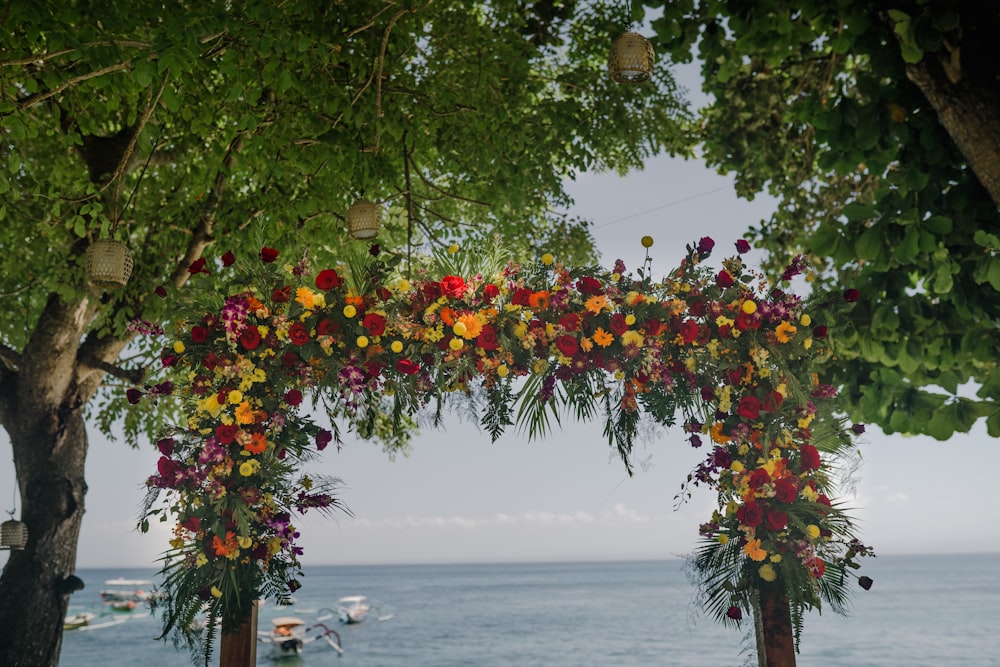 a wedding arch decorated with flowers by the ocean