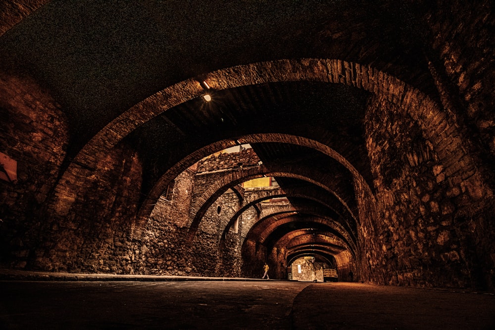 a dark tunnel with a person walking in it