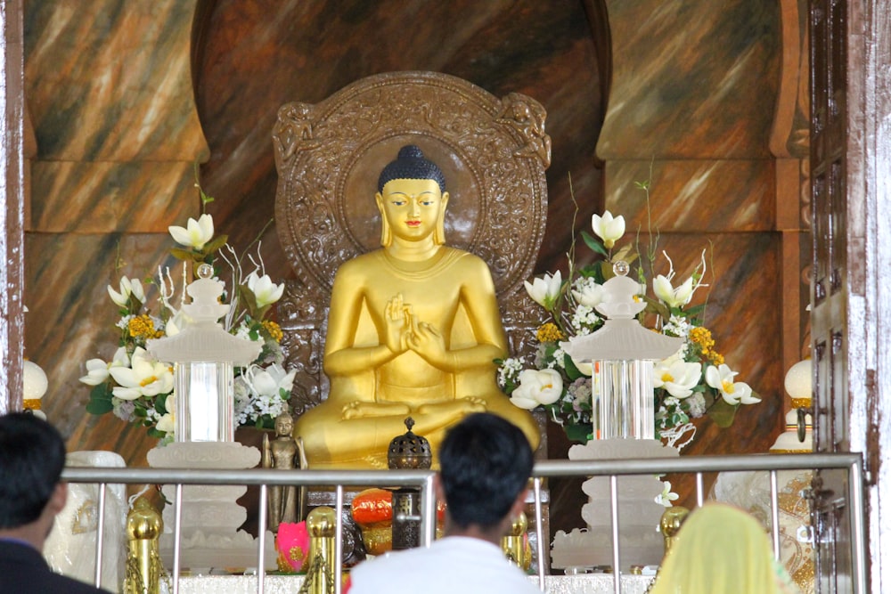 a large golden buddha statue sitting in a room