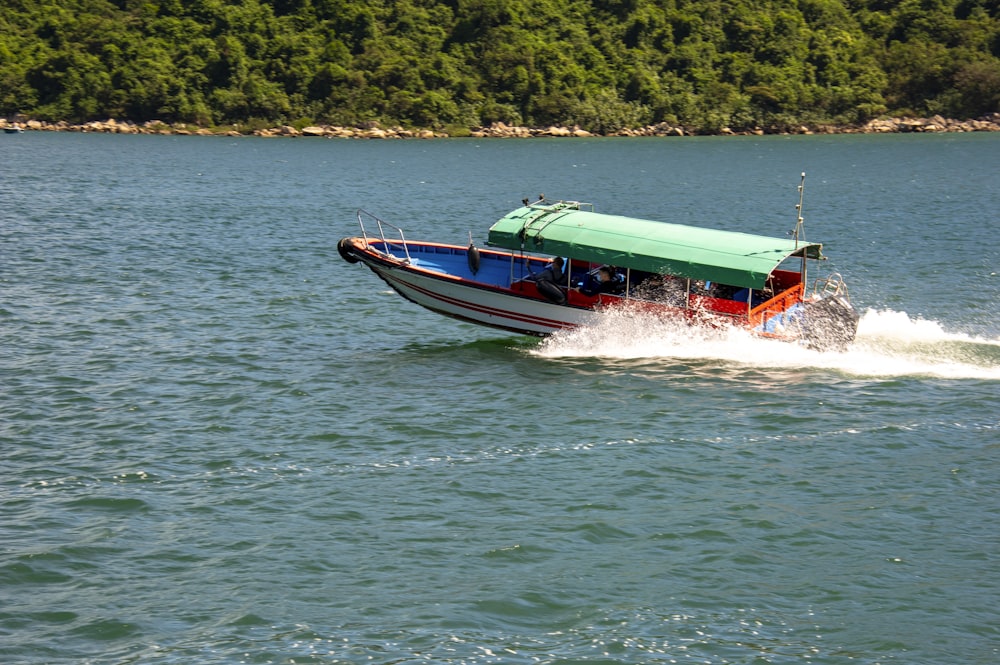 a boat with a green roof is in the water