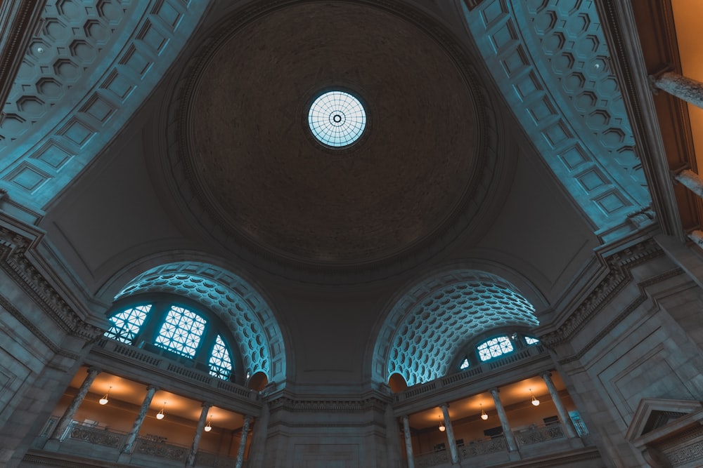 the ceiling of a large building with a circular window