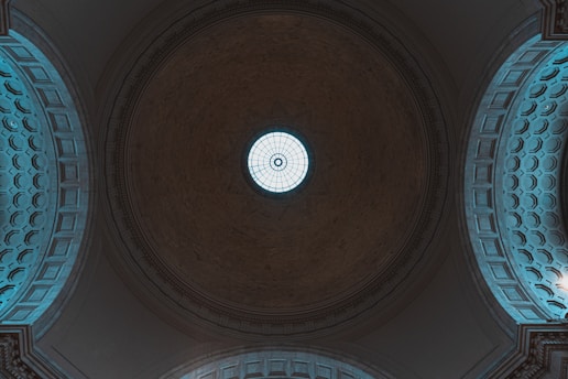 the ceiling of a building with a circular window