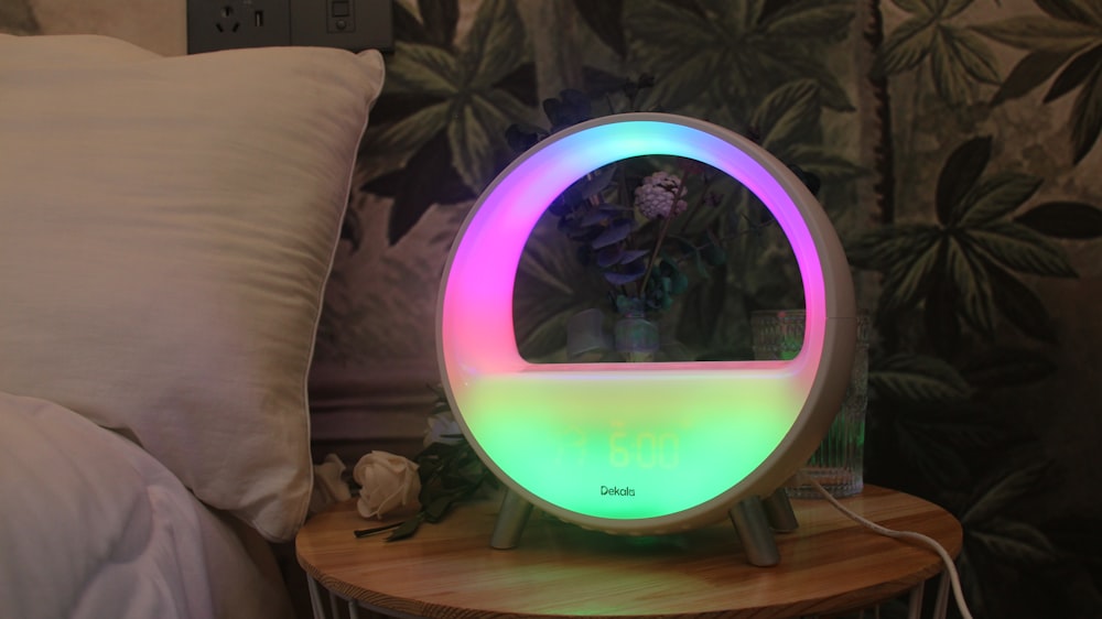 a colorful light up mirror sitting on top of a wooden table