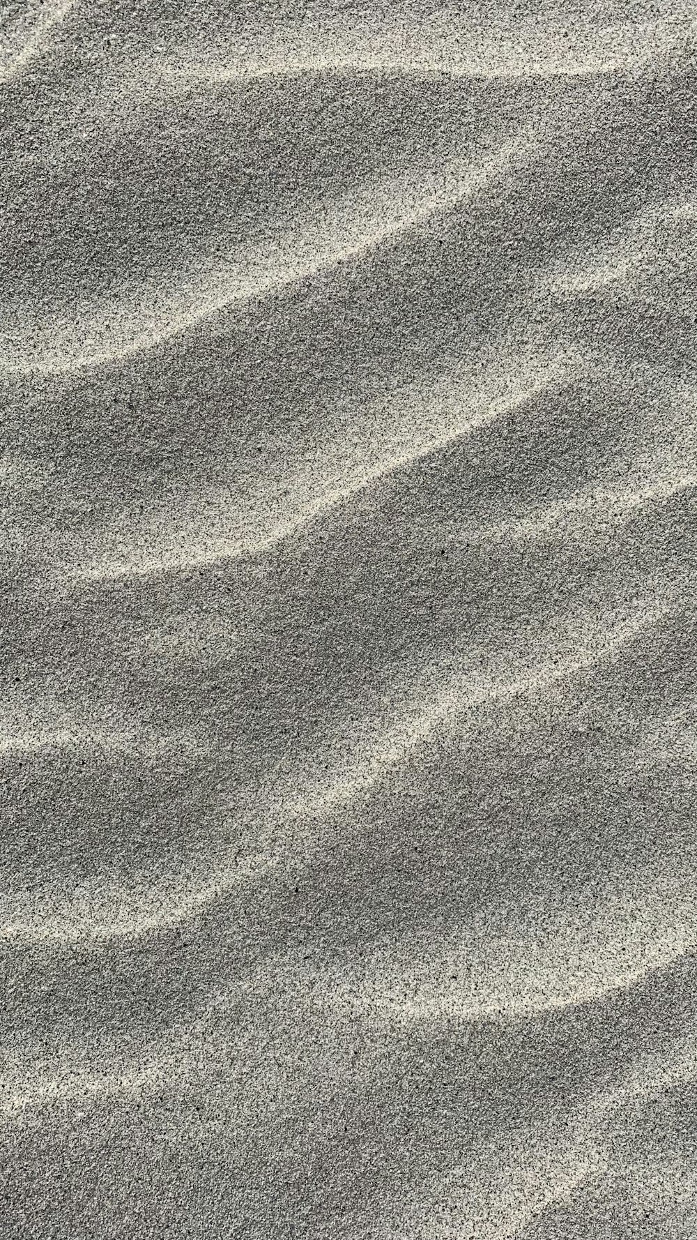 a sandy beach with small waves in the sand