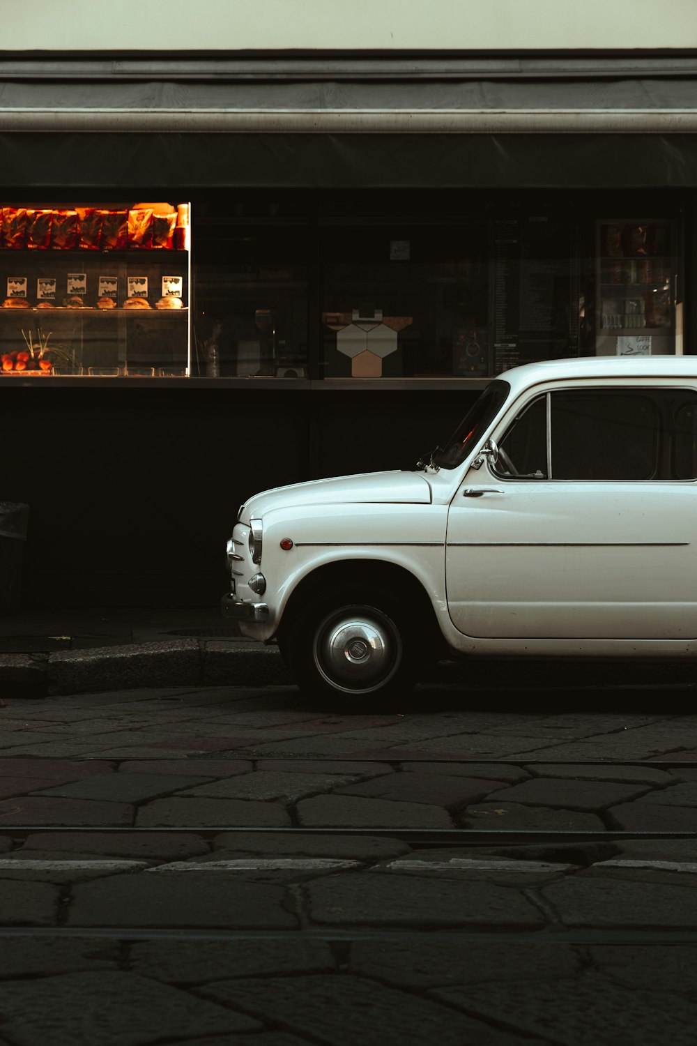 a white car parked in front of a store