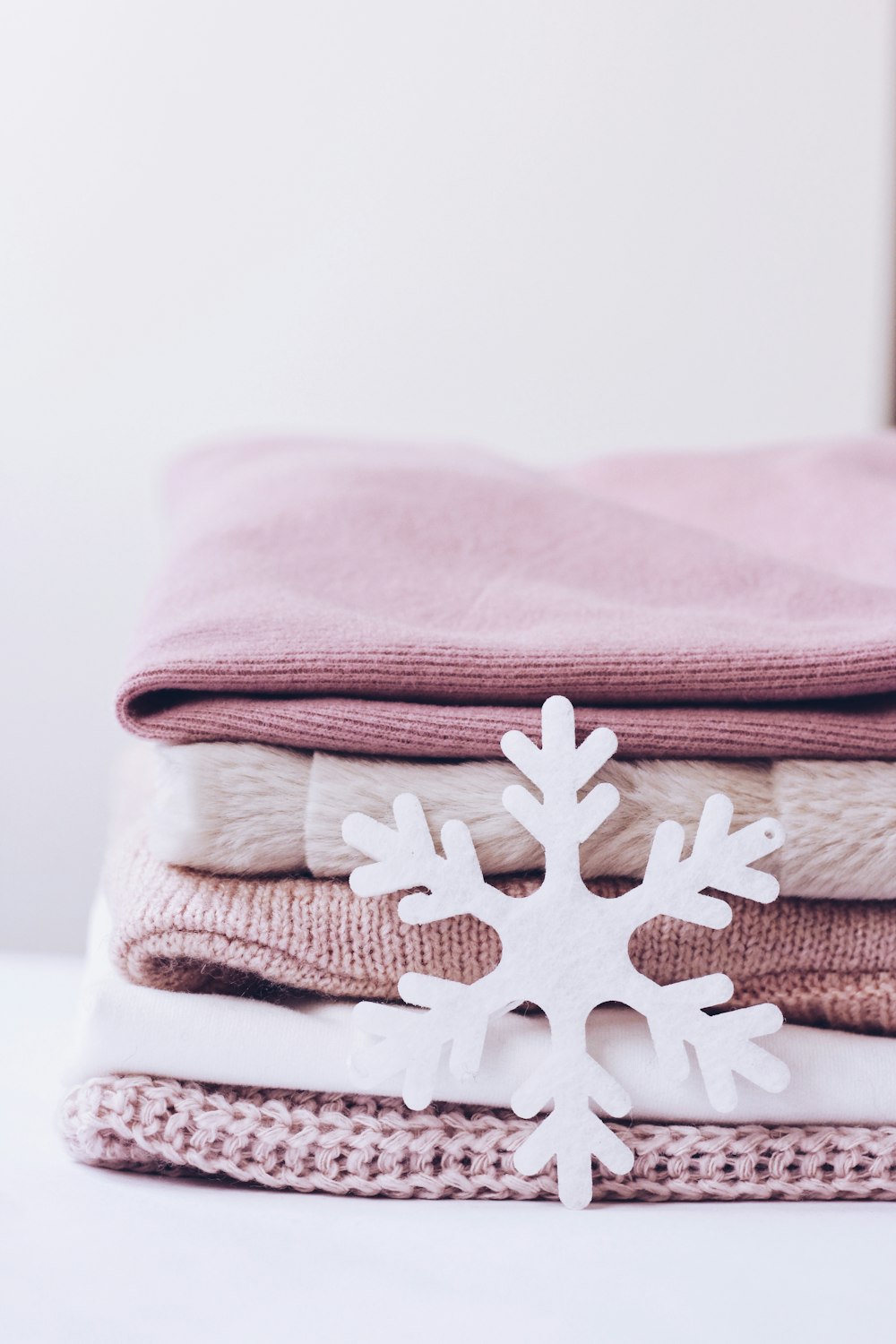 a pile of folded clothes with a snowflake on top