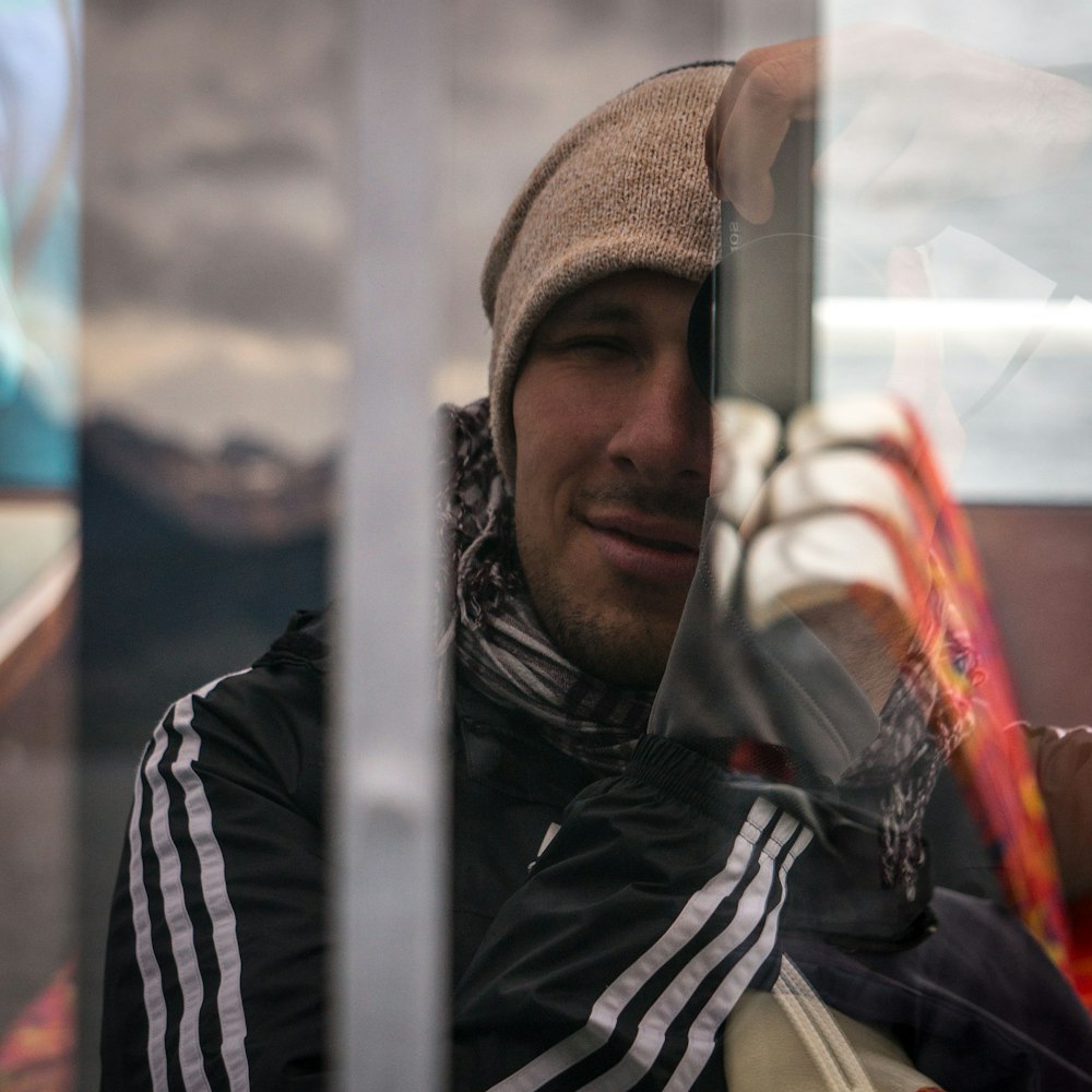 a man wearing a hat and scarf on a bus