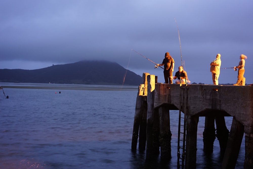 a group of people standing on top of a pier