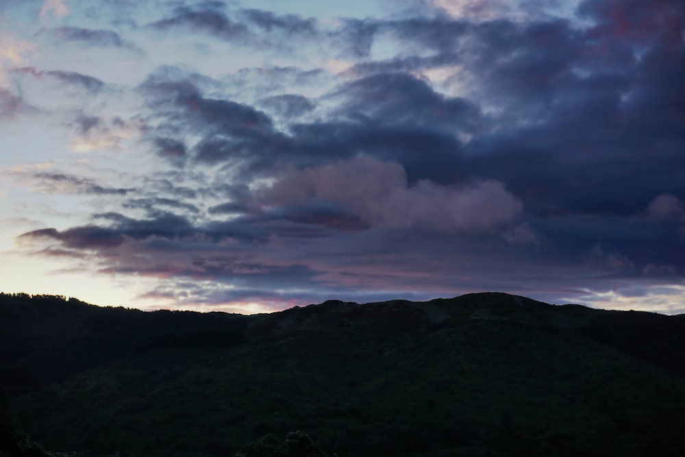 a view of a mountain with clouds in the sky