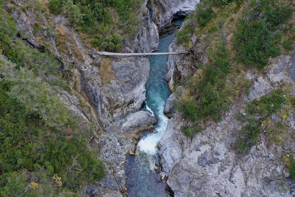 a suspension bridge over a river in a canyon