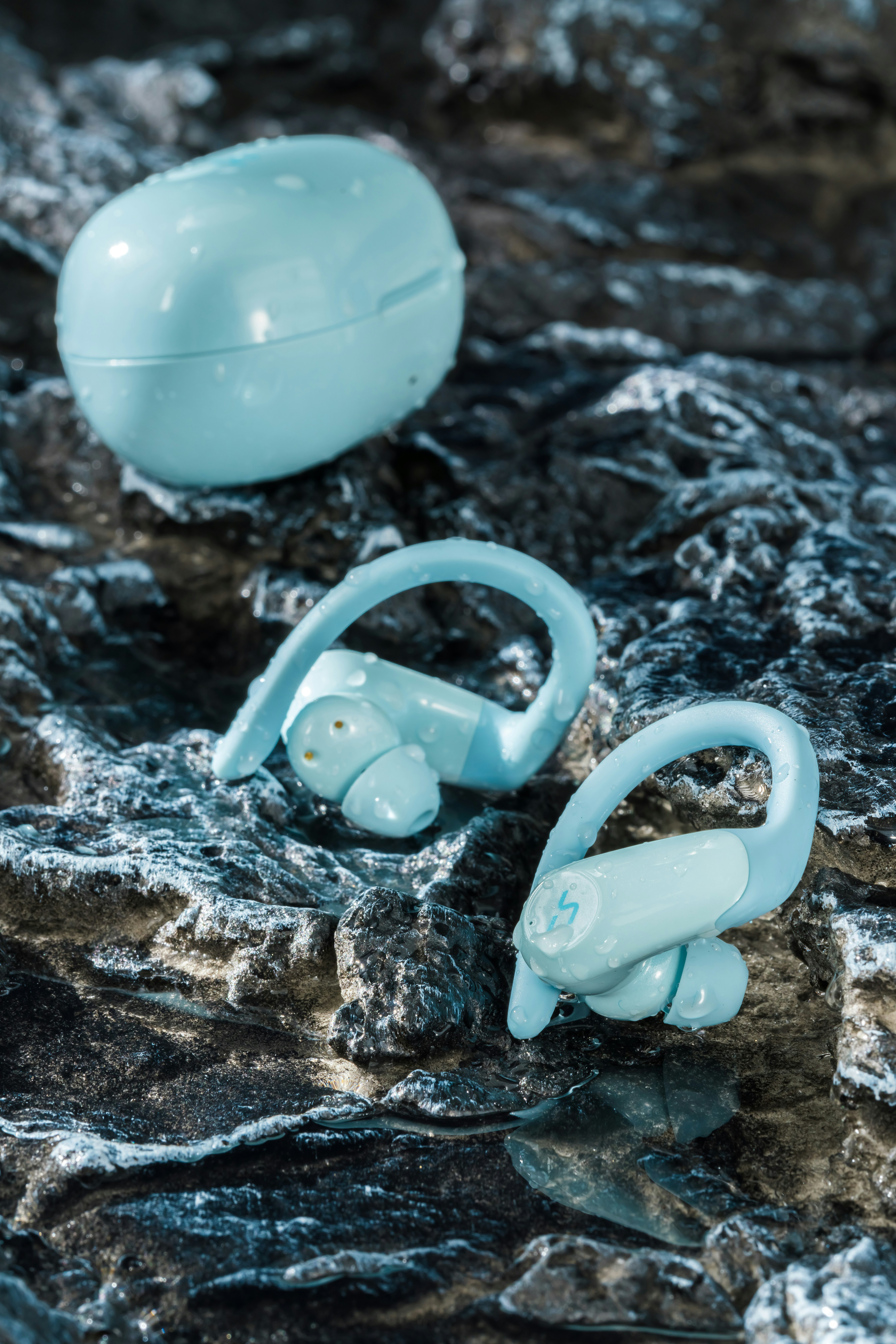 a pair of blue ear buds sitting on top of a rock