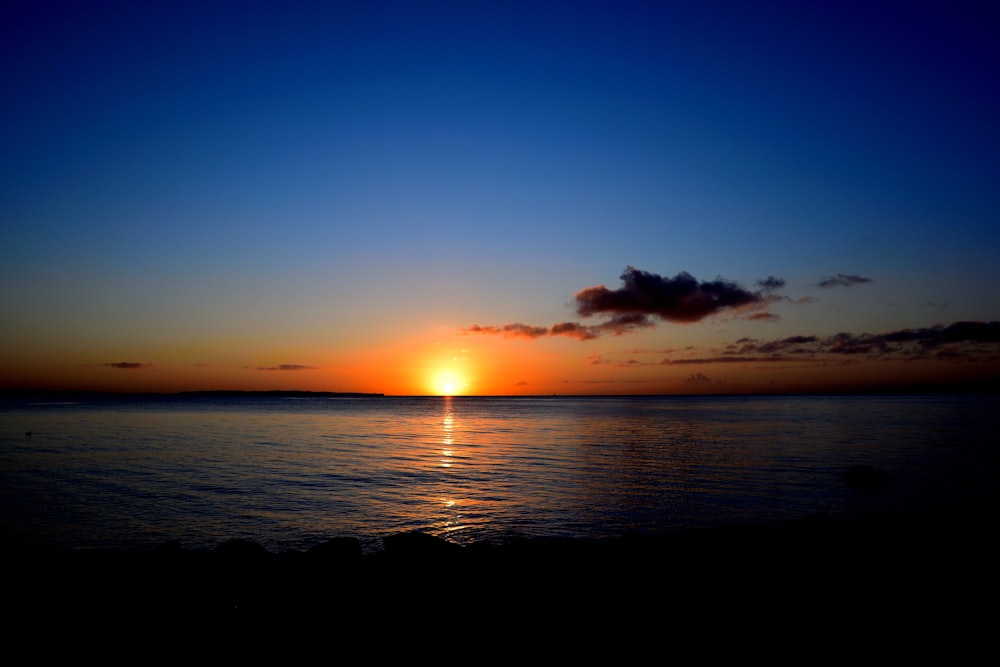 the sun is setting over the ocean on a clear day