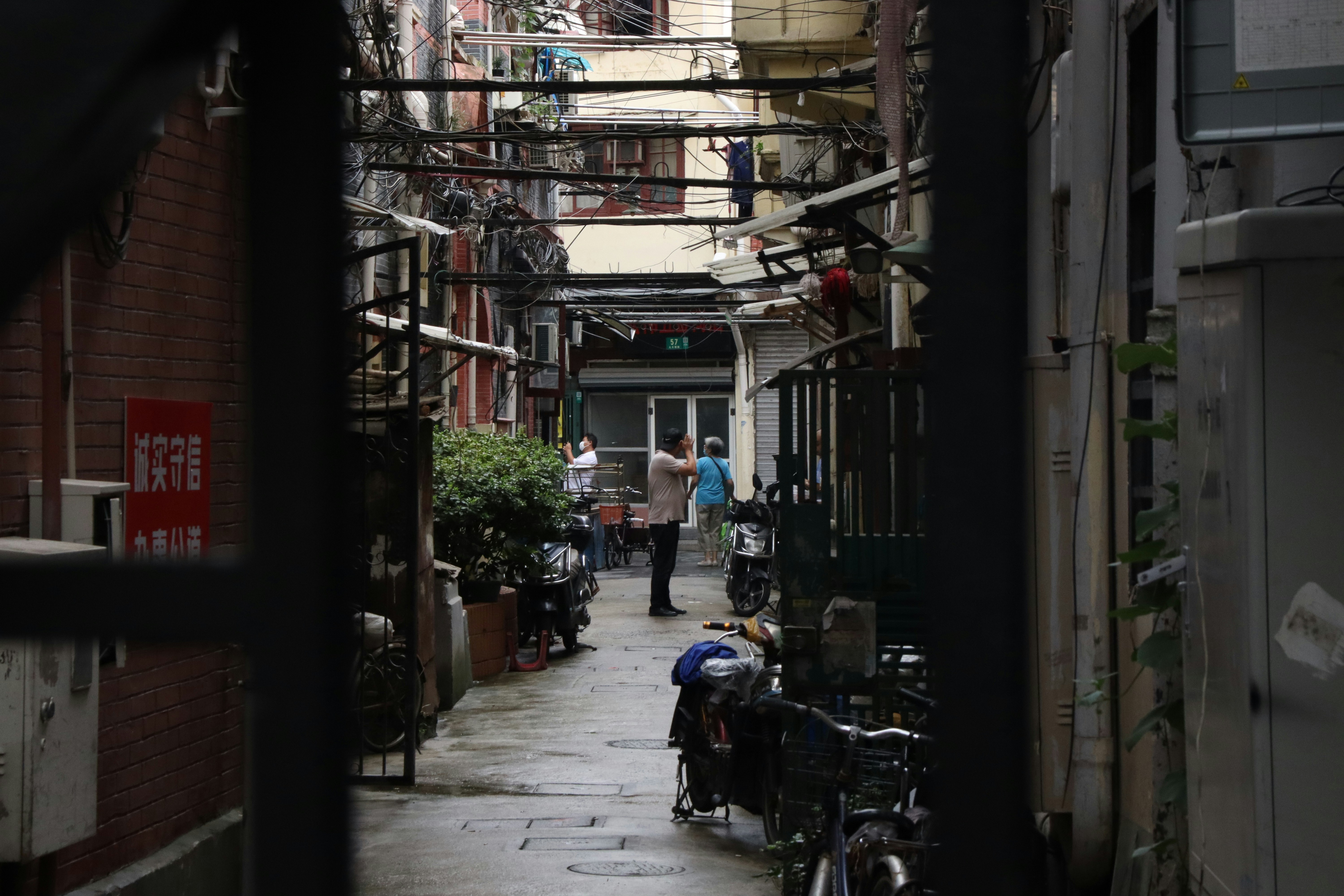a narrow alley way with people walking down it