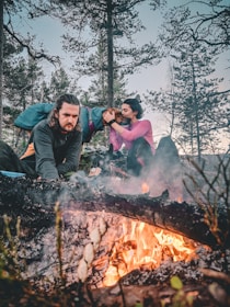 A veteran and his dog share a quiet moment by a sunlit campfire in the backcountry.