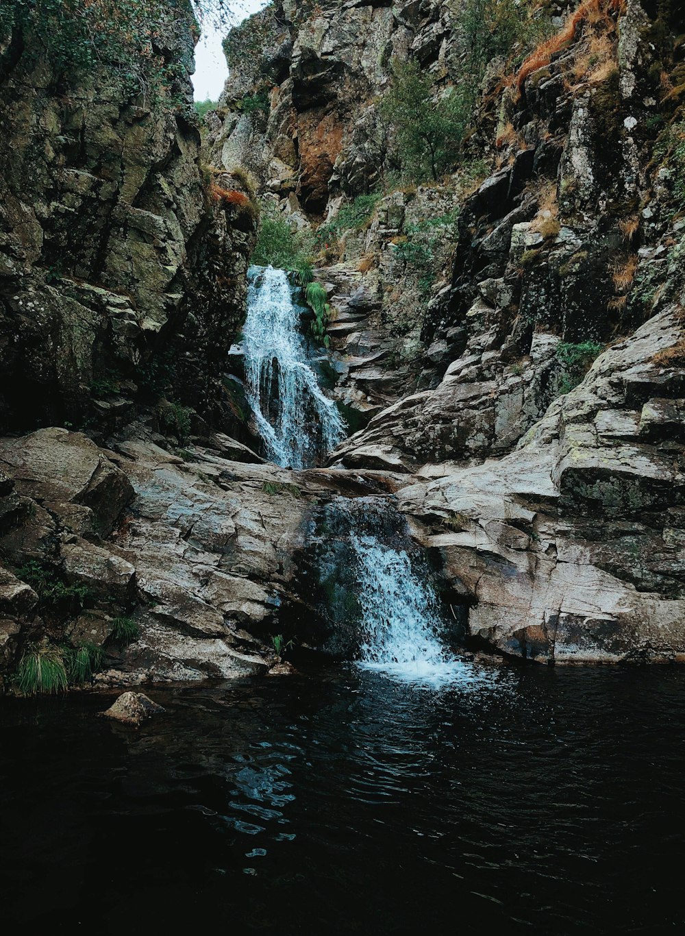 a small waterfall in the middle of a rocky area